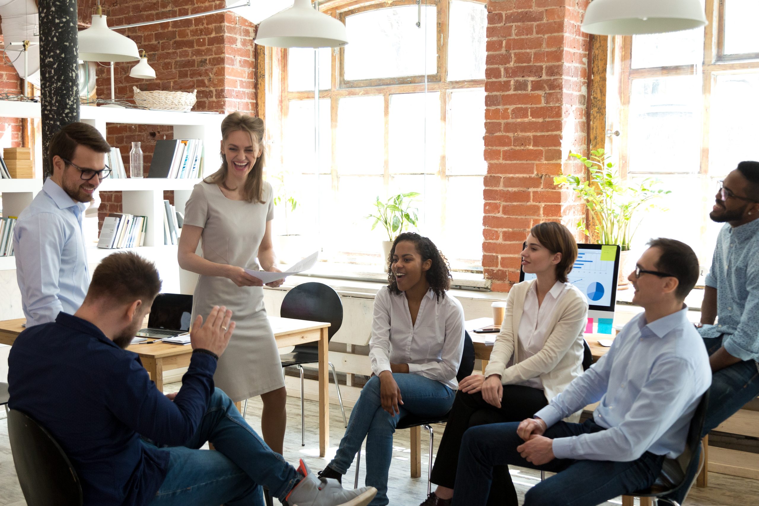 Happy friendly business team having fun at corporate training, funny teambuilding activity, diverse employees group laughing at briefing, colleagues joking together at meeting, staff good relations